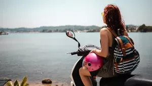 Chica montada en moto mirando el mar